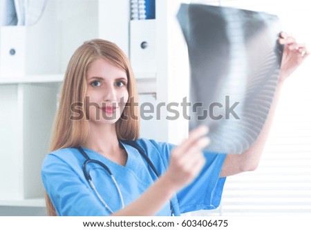 Young female doctor looking at the x-ray picture