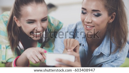 Two girls taking pictures on the phone