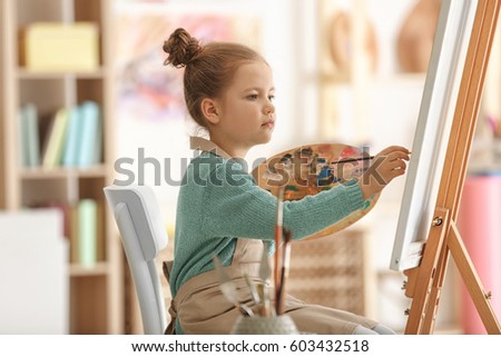 Cute little artist painting picture in studio Royalty-Free Stock Photo #603432518