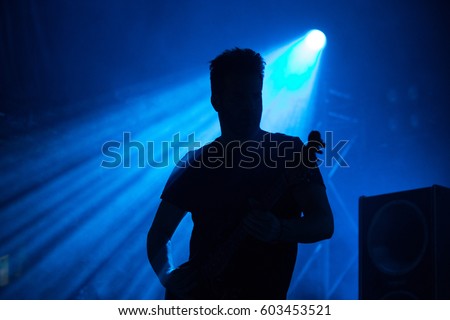 Man Silhouette playing guitar on stage