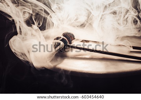 drum and drumsticks. Sticks with balls lie on the drum. in the smoke