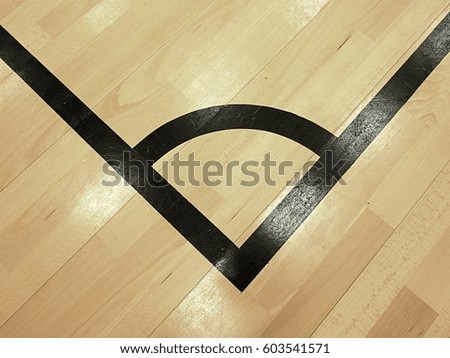 Black corner. Worn out wooden floor of sports hall with colorful marking lines