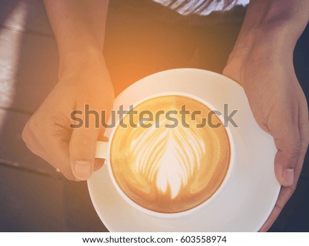Holding Cup of hot latte art coffee