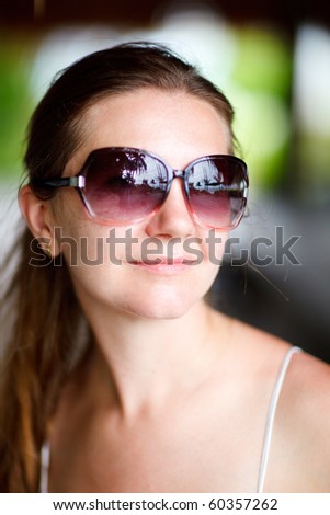 Outdoor portrait of young beautiful woman in sunglasses