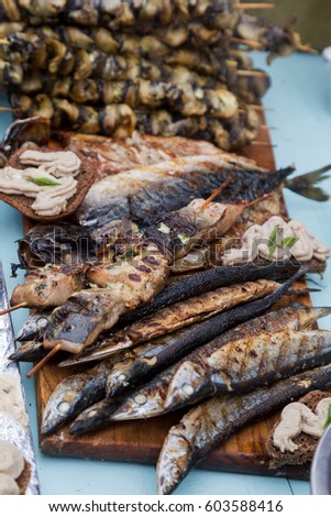 Creative background for advertising menu: Fried fish, Blue cockleshell mussels on skewers grill. beautiful picture for an advertising menu of healthy dietary seafood dishes. Selective focus
