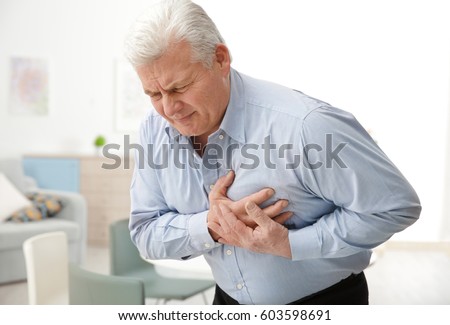 Man with chest pain suffering from heart attack in office Royalty-Free Stock Photo #603598691