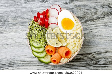 Veggies detox Buddha bowl recipe with egg, carrots, sprouts, couscous, cucumber, radishes and seeds. Top view, flat lay, copy space 