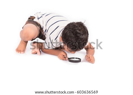 Cute asian little boy play magnifying glass