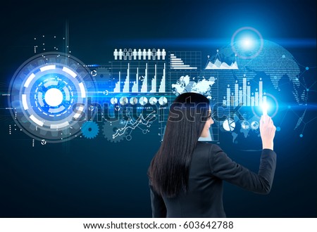 Rear view of a businesswoman drawing graphs on a glassboard. It is glowing blue. Toned image. Elements of this image furnished by NASA