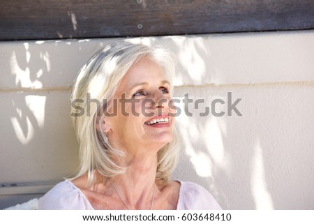 Close up portrait of beautiful older woman smiling outside looking relaxed 