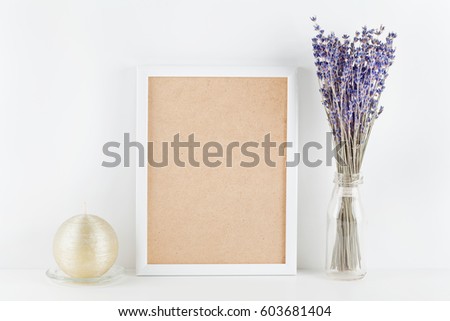 Mockup of picture frame decorated lavender flowers in vase on white working desk with clean space for text and design your blogging. 