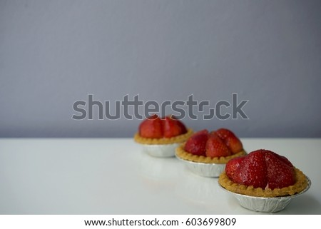 Sweet strawberry cakes on white background against grey wall. Full frame image. Horizontal picture with copyspace.