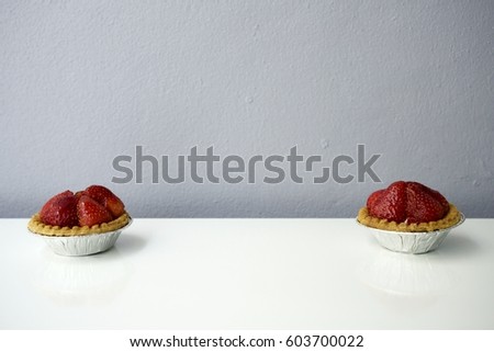 Sweet strawberry cakes on white background against gray wall. Full frame image. Horizontal picture with copyspace.