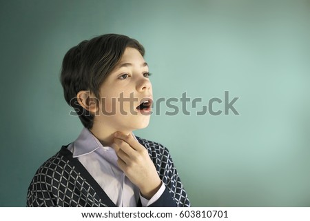 teen singer boy sing close up portrait on blue background Royalty-Free Stock Photo #603810701