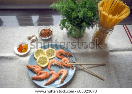 Shrimps and lemon slices on plate, ready to prepare lunch