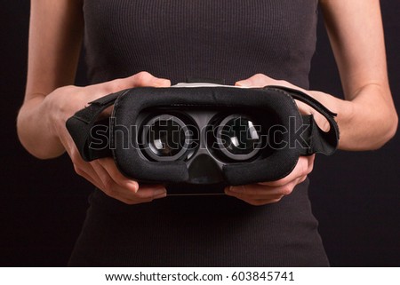 Girl hold modern virtual reality glasses for mobile game application.Close up, focus on headset in woman hands