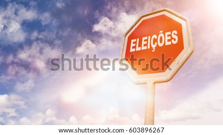 Eleicoes, Portuguese text for Elections, text on red traffic stop sign in front of cloudy blue sky with lens flares
