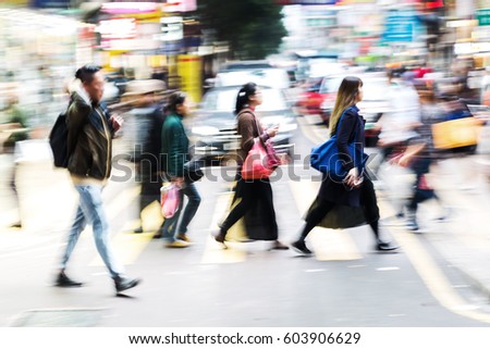 picture with motion blur of a crowd of people crossing a street in Hongkong