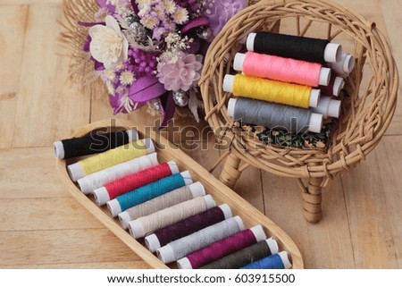 Colorful thread for sewing on wood background