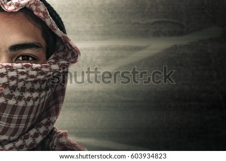 terrorists half face and eyes contact with masked and grunge background, terrorism and criminal concept Royalty-Free Stock Photo #603934823