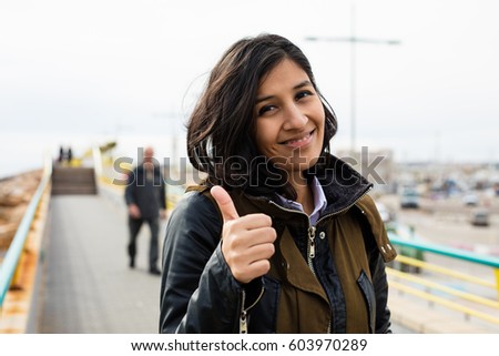 young woman doing gesture ok in the street