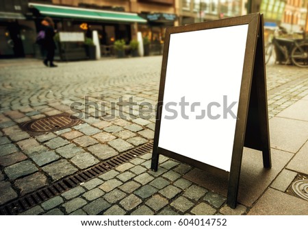 Blank restaurant advertising board as copy space on the street. Angled freestanding A-frame blackboard for mockup design.