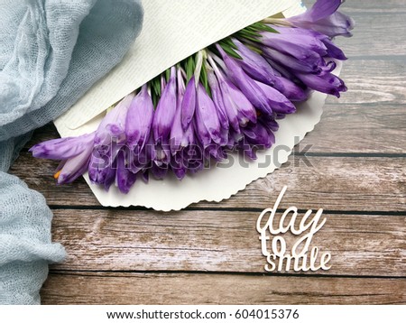 Day to smile. Crocuses in envelope on wooden background. Concept crocus background. 