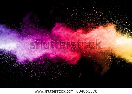 Abstract art colored powder on black background. Frozen abstract movement of dust explosion multiple colors on black background. Stop the movement of multicolored powder on dark background. Royalty-Free Stock Photo #604051598