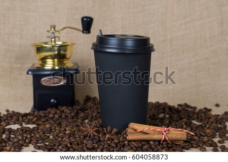 Coffee to go cup on burlap background with cinnamon