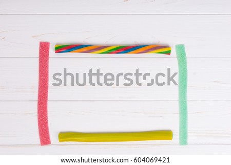 Colorful tasty licorice and chewy candies on wooden white board