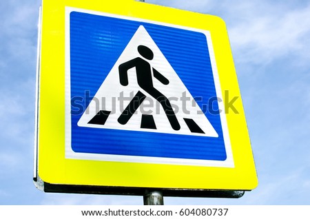 Road sign pedestrian crossing in background blue sky
