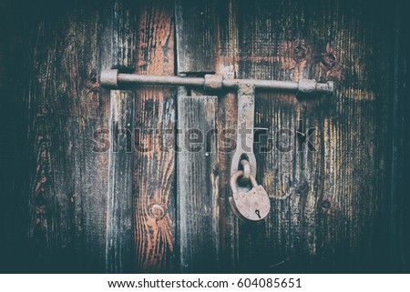 Wooden door surface with padlock, abstract background. The effect of two layers