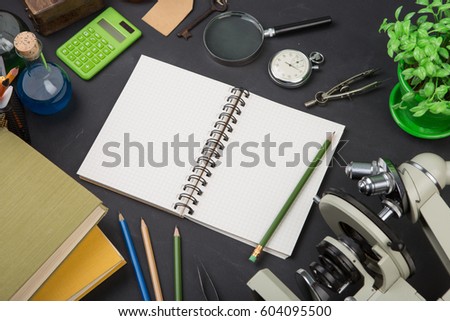 Education concept - books and microscope on the desk in the auditorium