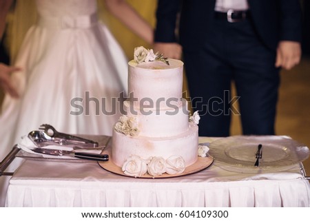 Gorgeous wedding cake covered with pink glaze and little flowers