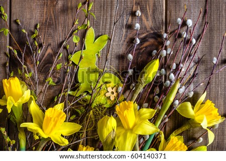 Background with easter eggs, rabbit and daffodils on wooden table