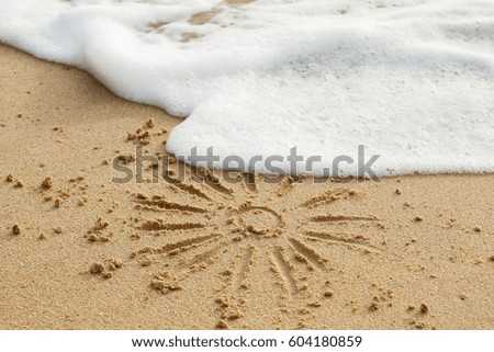 Drawing of sun on the sand and wave foam