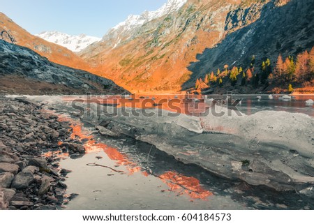 Iced lake between the mountains at sunset