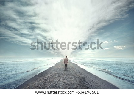 man walking between two seas Royalty-Free Stock Photo #604198601