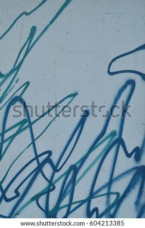 Detailed photo of street graffiti drawing from different colors and shapes. Concept of street art, fine arts of youth, hooliganism and vandalism. Texture of the wall, decorated in graffiti style
