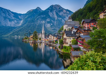 Scenic picture-postcard view of famous historic Hallstatt mountain village with Hallstattersee in the Austrian Alps in mystic twilight during blue hour at dawn in summer, Salzkammergut region, Austria
