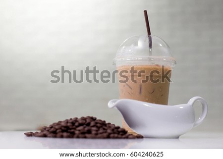 Ice coffee  with coffee beans and jar on modern kitchen table.