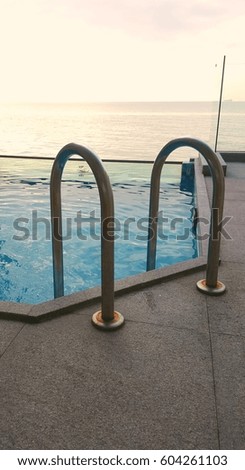 Close up image of pool handlebars during sunset.