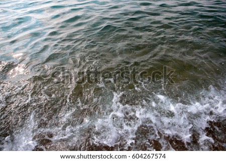 Clean clear sea water and fine sand on the bottom