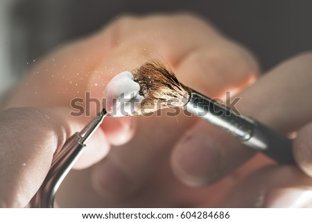 Dental prosthesis, artificial tooth, prosthetic, hands working on the denture, false teeth. Royalty-Free Stock Photo #604284686