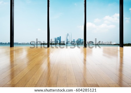 empty wooden floor near river with background of modern city