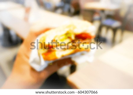 Picture blurred abstract background of hand hold burger