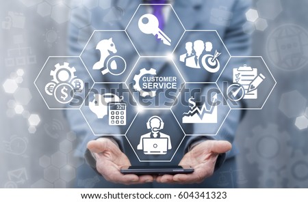 Customer Service Concept. Department Team Support Business. Businessman offers smart phone with customers services icon on virtual screen. Care Technology. Royalty-Free Stock Photo #604341323