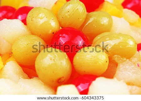 Fruit salad texture. Fruits as background pattern. Exotic Fruits  Fruit salad with cocktail cherry sour cherry mango pineapple grapes,pear,papaya in syrup.