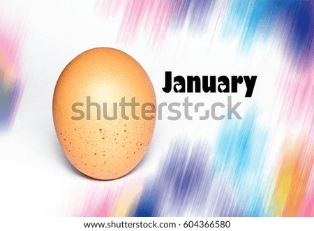 conceptual image of egg and word-January with abstract colour as background