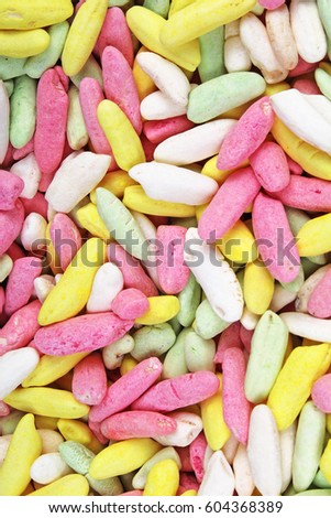 Candy from puffed rice grains. Sweet flavored puffed rice grains. Colorful snack.